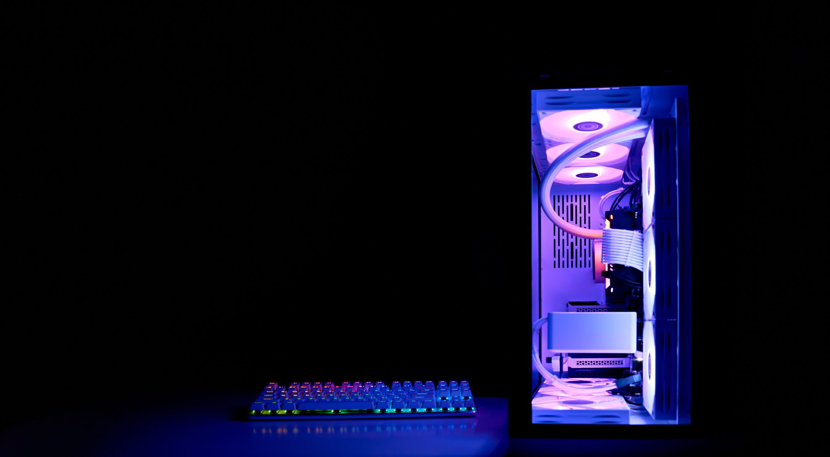 Gaming PC with rainbow LED light. Modern liquid cooled gaming computer. Powerful PC in a glass case, front view.